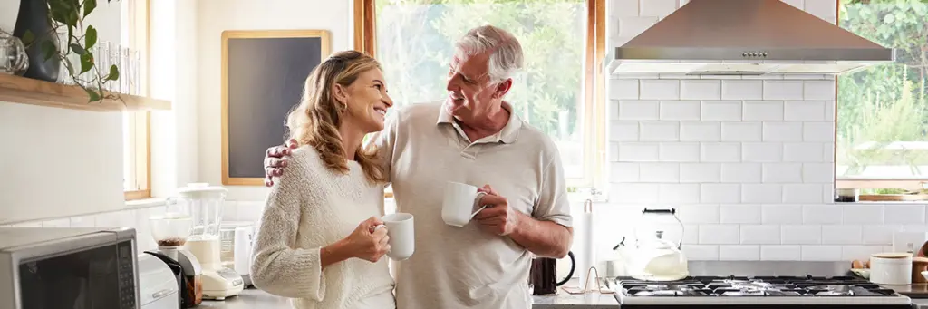 Legal Advice for Unmarried Couples - Picture of a couple holding up a wooden frame in the shape of a house.