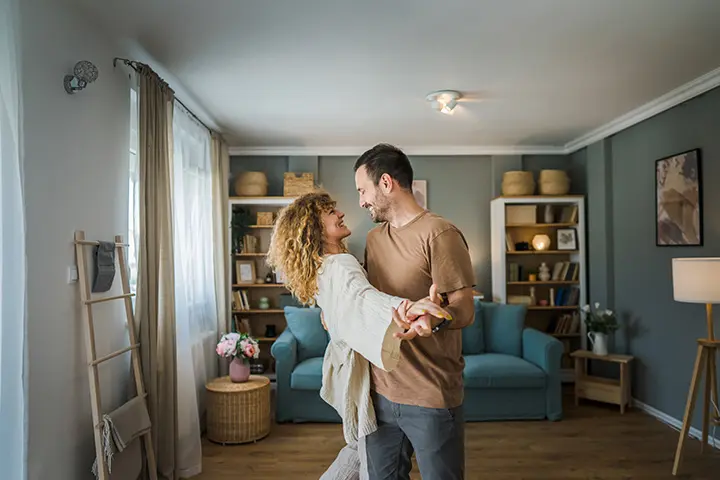 Legal Advice for Unmarried Couples - Picture of a couple holding up a wooden frame in the shape of a house.