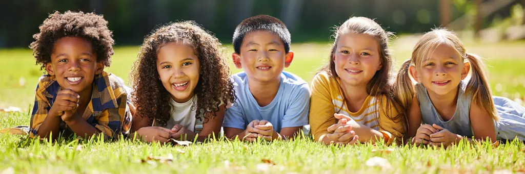 International Adoption Solicitors - Picture of children laid on the floor smiling.