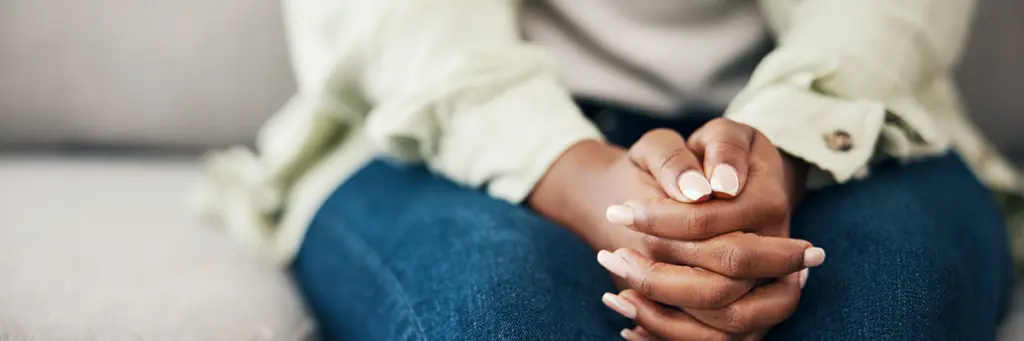 Domestic Abuse - Close up picture of a female's hands tightly clasped.
