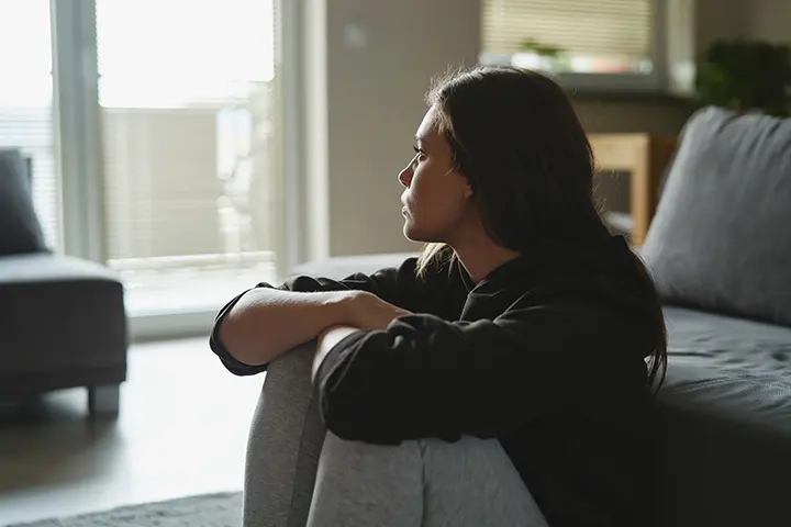 Domestic Abuse - Picture of a female gazing out of the window with a troubled expression.
