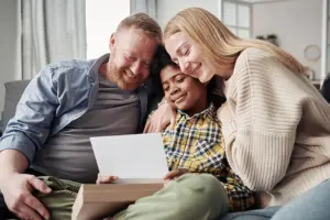 Post Adoption Contact - Picture of a family with an adopted child reading a letter from the birth parents.